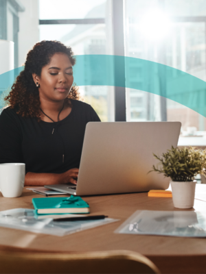 woman sitting at a computer drinking coffee